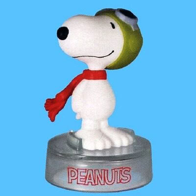 Peanuts Snoopy figure with green helmet and red scarf, standing on round "PEANUTS" base