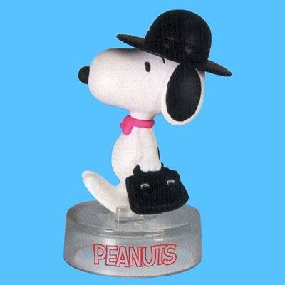 Peanuts Snoopy figure with black cap and pink collar, standing on round "PEANUTS" base