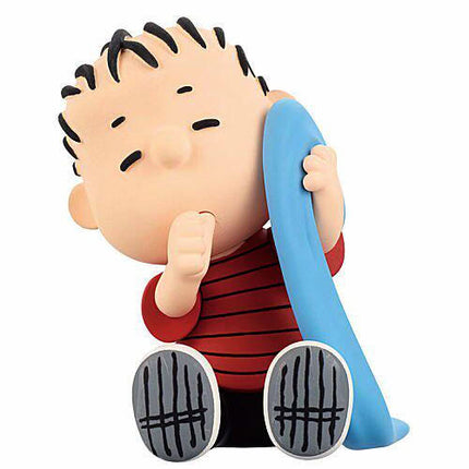 Charlie Brown sleeping capsule toy figure with blue blanket and red striped shirt