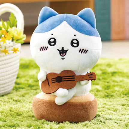 Plush cat toy with blue ears and brown guitar, sitting on a green surface