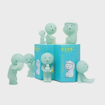 A group of small, light blue figurines with various poses and expressions, arranged on a blue background.