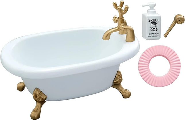 a white clawfoot bathtub with gold accents, accompanied by a pink bath mat and a bottle of shampoo.