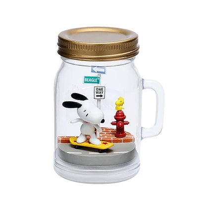 A figurine of a cartoon character, likely a character from the Peanuts comic strip, is depicted inside a glass jar with a lid. The figurine is riding a skateboard and appears to be in a city setting, with a fire hydrant and a street sign visible in the background.