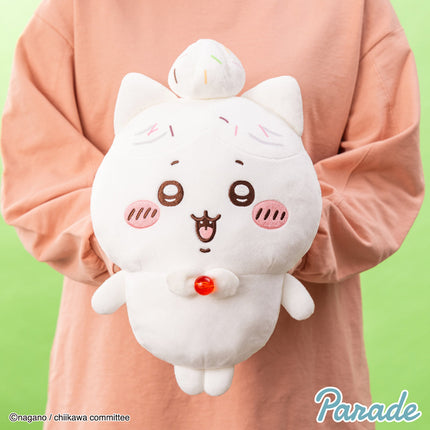 White big plush toy with bowlike ears, cat face, and a red bell detail on chest.