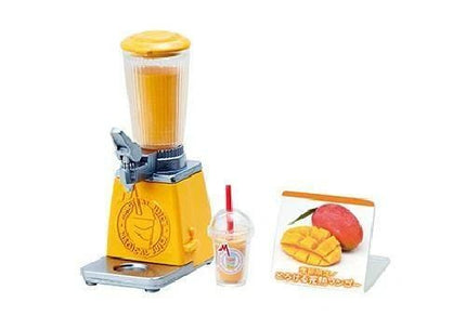 A yellow blender with a clear plastic cup and a picture of a mango on a sign are displayed in the image.
