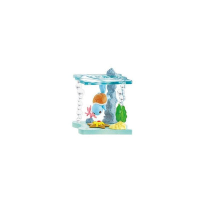 A toy underwater scene with a blue toy fish, a green toy plant, and a yellow toy starfish.