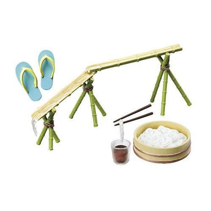 A toy set depicting a bamboo bridge with a pair of blue flip flops on the left side and a bowl of rice on the right side.
