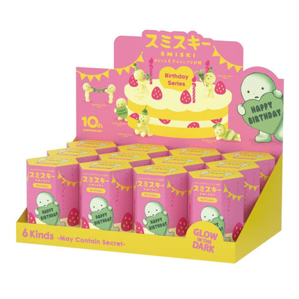 A pink and yellow display case containing multiple boxes with cartoon characters and a birthday cake.