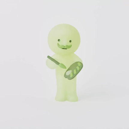 A small, glowing green figurine holding a paintbrush and palette, standing against a white background.