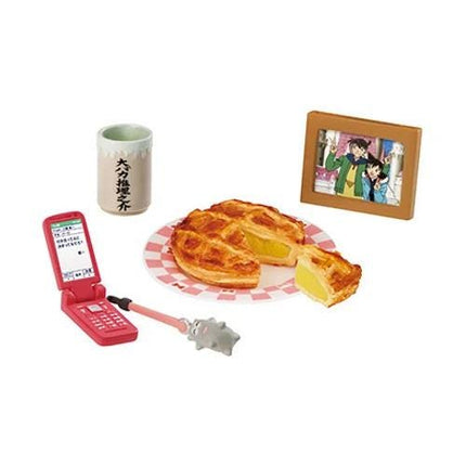 a cell phone, a cup, a plate with a pie, and a picture frame.
