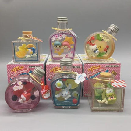 A collection of six colorful glass bottles with various designs and characters, including a kiwi and a character from the Hello Kitty franchise.