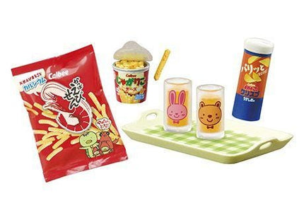 various snacks and drinks, including a bag of shrimp chips, a cup of what appears to be a beverage, and two glasses with cartoon rabbit and bear designs.