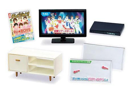 various items, including a television, a magazine, a DVD player, a white cabinet, and a white sign with Japanese text.