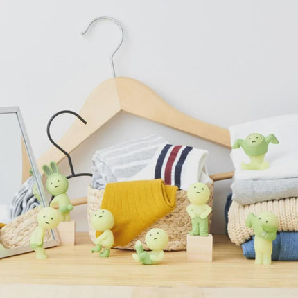 a collection of various items, including a wooden hanger, a basket, and several small figurines, all arranged on a wooden surface.