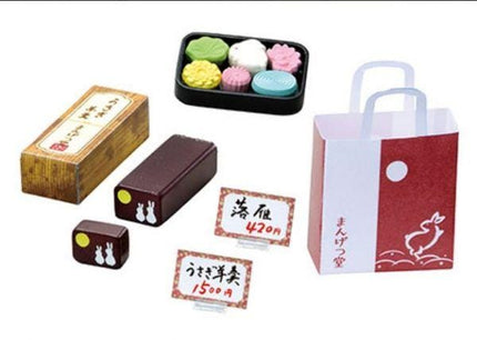 various items, including a box, a bag, and some small objects, all of which appear to be related to Japanese culture or cuisine.