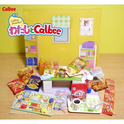 The image is a colorful display of various snacks and drinks, including chips, candy, and beverages, arranged on a table or counter.