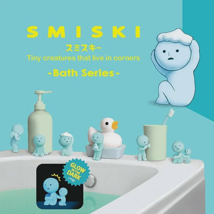 The image is a collage featuring various small figurines and objects, including a bathtub, a bottle, a duck, and a toothbrush, all set against a blue background.