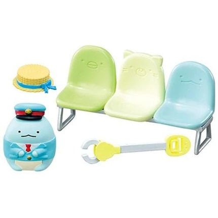 A toy set featuring a blue hat, three chairs, and a toy train.