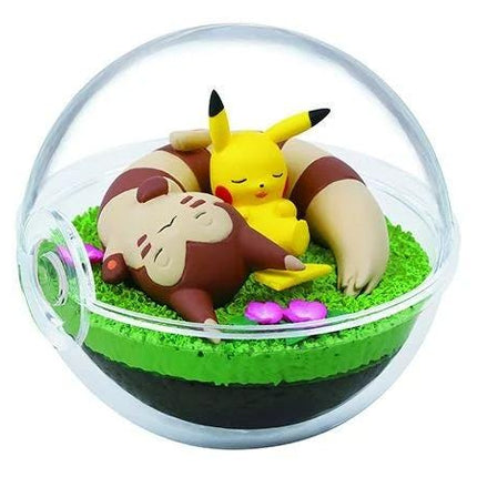 A figurine of Pikachu and a brown monkey are depicted in a glass terrarium, with the Pikachu figurine sleeping and the monkey curled up next to it.