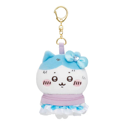 White and light-blue plush cat keychain with gold clasp, bow, and pink ruffled skirt