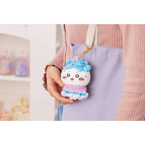 Cute plush keychain with white cat face, light blue bow, ruffled skirt, gold ring