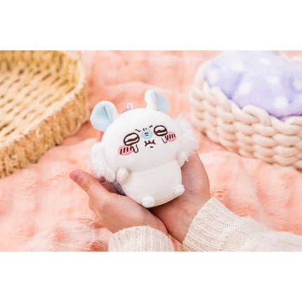 Hand holding a white plush mascot holder with light blue ears and cute face