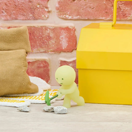 Smiski Construction Series blind box figure kneeling by yellow tool case and green cloth