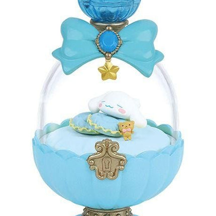 A blue and gold perfume bottle with a glass dome, containing a sleeping plush toy and a small gold star.