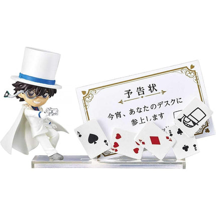 A figurine of a person wearing a top hat and holding a deck of playing cards, standing next to a card holder with playing cards.