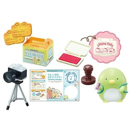 various small objects, including a camera, stamps, cookies, and a penguin figurine.