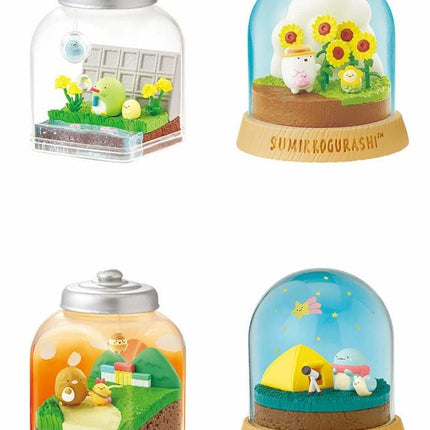 four different snow globes, each containing a miniature landscape scene with various elements such as animals, plants, and structures.