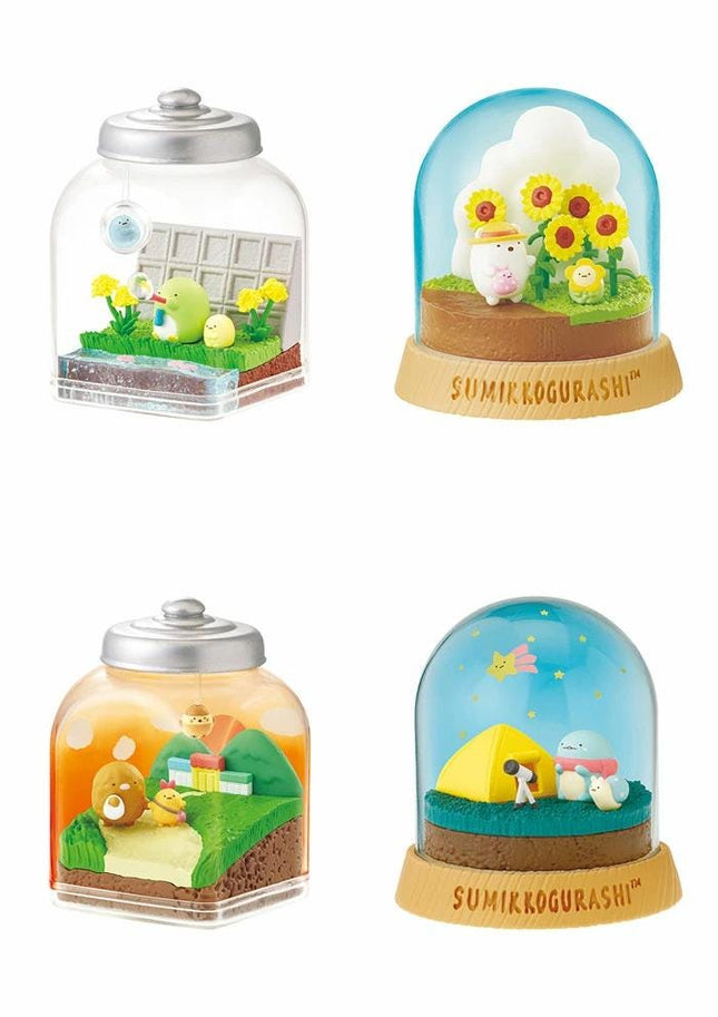 four different snow globes, each containing a miniature landscape scene with various elements such as animals, plants, and structures.