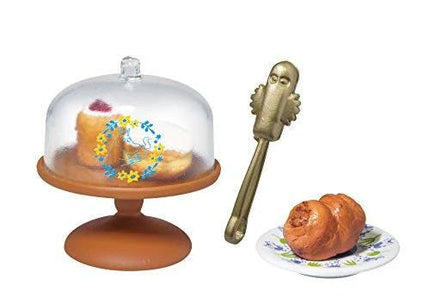 a cake stand with a cake on it, a pastry cutter, and a plate with pastries.