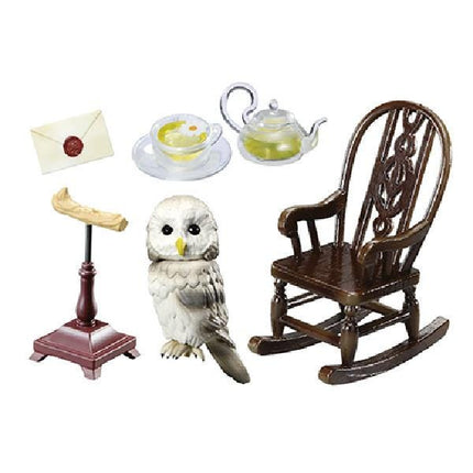 a variety of objects, including a wooden rocking chair, a teapot, a cup, an envelope, and a small owl figurine.
