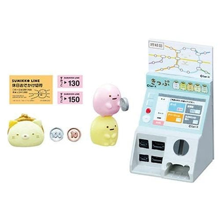 a toy vending machine with various small figures, including a pink character, a yellow character, and a cat figure. The vending machine also has a map and some tickets displayed on it.