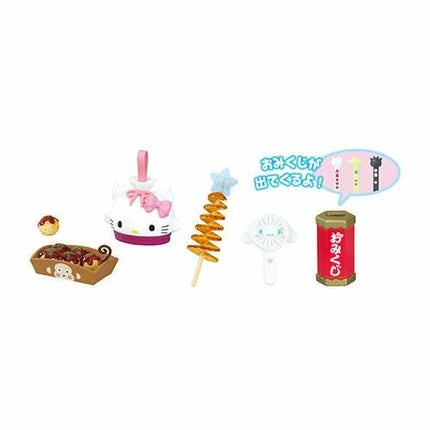 various food items and a speech bubble with text, including a Hello Kitty doll, a spiral-shaped object, a red can, and a speech bubble with text.