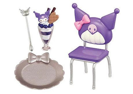 a purple cat-shaped chair, a glass with a dessert, and a silver spoon.