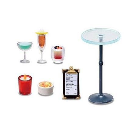 various objects, including a glass table, a red candle, a white bowl, a small glass container, and a small white bowl.