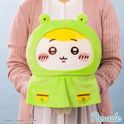 Bright green hooded plush toy with yellow inner hood, sleepy eyes, and smiling face