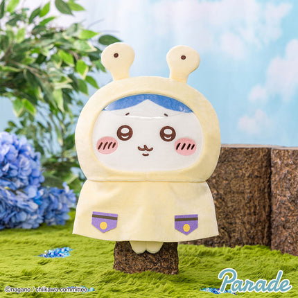 Light tan hooded plush toy with rabbit ears, blue inner hood, and smiling embroidered face