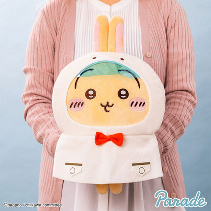 Cream-and-yellow hooded plush toy with orange bow tie, rabbit ears, and stitched smile