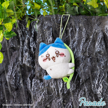 Plush mascot keychain, white character with blue hood, green strap, stitched face