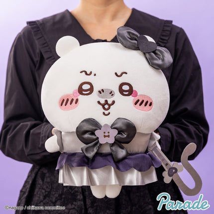Panda-like plush toy with black bow detail and purple ruffle skirt on a person