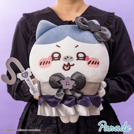 Panda-like plush toy with light blue hood, black bow, and purple ruffle skirt