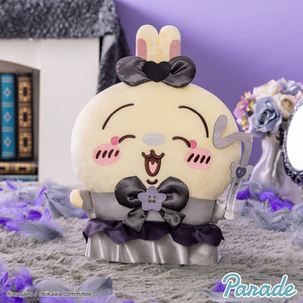 Round cream panda-like plush toy with bunny-ear black bow and purple ruffle skirt