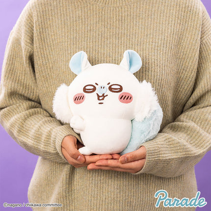 White plush toy with light blue ear tips and brown-red face, cradled in hands