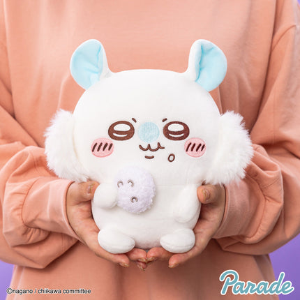 White plush toy with blue ears and brown face, cradled in hands with small squirrel plush