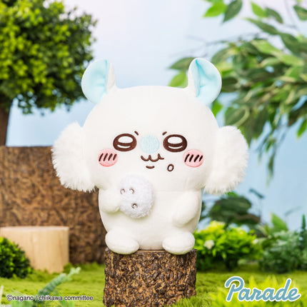White plush toy with blue ears, brown face, and small squirrel plush held at center