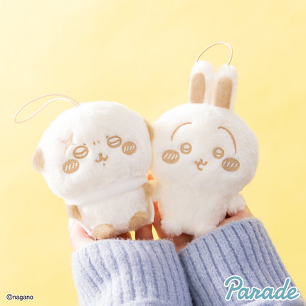 Two light cream plush mascots with long ears in blue striped sleeves