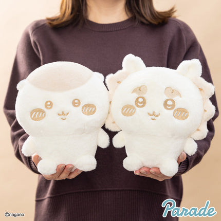 Two milk-color cat plush toys held up, each with embroidered eyes and ear tufts